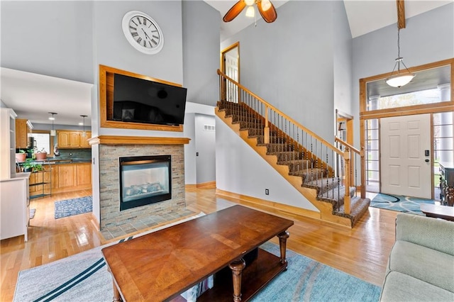 8110 NE 72nd Ter, Kansas City, MO 64158 - living room with high vaulted ceiling, stairs, light wood-type flooring, and a multi sided fireplace