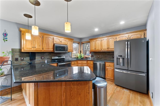 8110 NE 72nd Ter, Kansas City, MO 64158 - kitchen with light wood finished floors, decorative backsplash, a peninsula, and appliances with stainless steel finishes