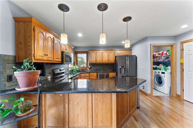 8110 NE 72nd Ter, Kansas City, MO 64158 - kitchen featuring tasteful backsplash, a peninsula, dark stone countertops, appliances with stainless steel finishes, and light wood finished floors
