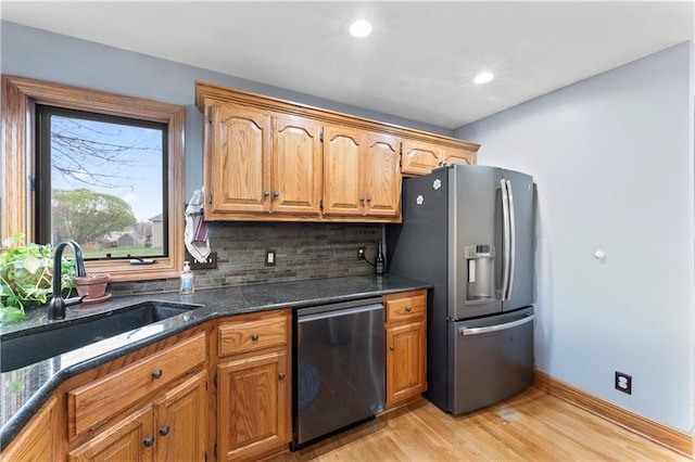 8110 NE 72nd Ter, Kansas City, MO 64158 - kitchen featuring a sink, appliances with stainless steel finishes, light wood-style floors, brown cabinets, and decorative backsplash