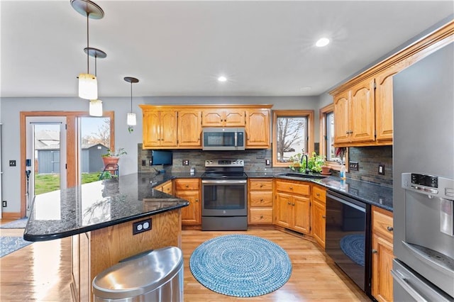 8110 NE 72nd Ter, Kansas City, MO 64158 - kitchen with a sink, a peninsula, light wood finished floors, stainless steel appliances, and decorative backsplash