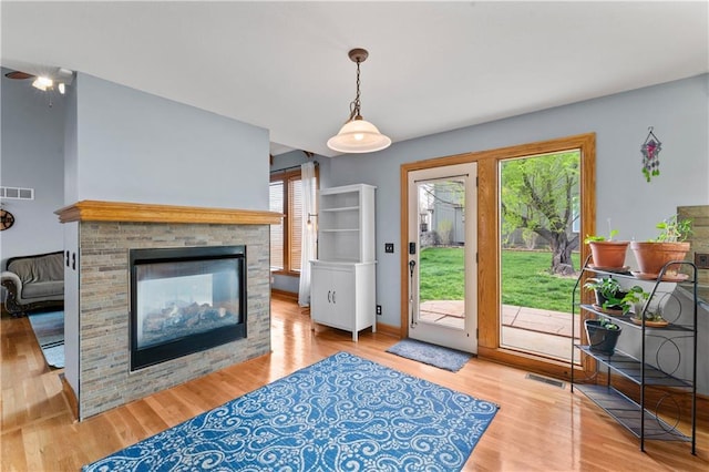 8110 NE 72nd Ter, Kansas City, MO 64158 - living room featuring visible vents, a multi sided fireplace, and wood finished floors