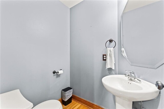 8110 NE 72nd Ter, Kansas City, MO 64158 - half bath featuring a sink, toilet, and wood finished floors