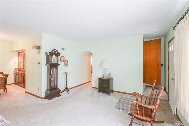 1601 S Market St, Holden, MO 64040 - sitting room with arched walkways, a textured ceiling, visible vents, carpet floors, and baseboards