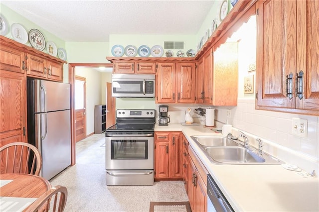 1601 S Market St, Holden, MO 64040 - kitchen with light countertops, a textured ceiling, visible vents, stainless steel appliances, and a sink