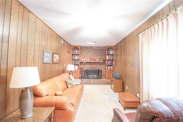 1601 S Market St, Holden, MO 64040 - carpeted living area featuring wood walls, a fireplace, visible vents, and a textured ceiling