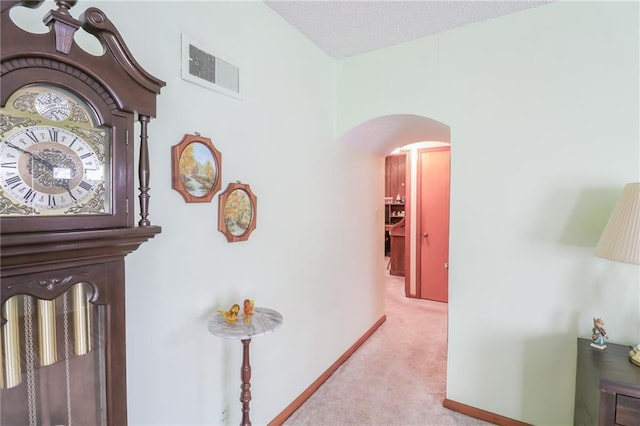 1601 S Market St, Holden, MO 64040 - hall with baseboards, a textured ceiling, carpet floors, visible vents, and arched walkways