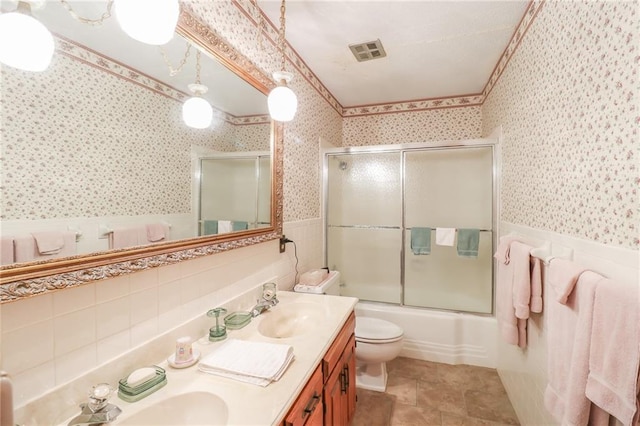 1601 S Market St, Holden, MO 64040 - bathroom with wallpapered walls, a wainscoted wall, visible vents, tile walls, and a sink