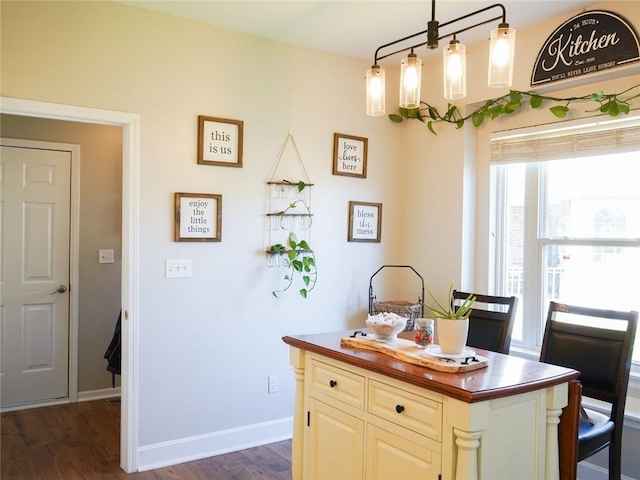 kitchen featuring a center island, baseboards, and dark wood-style flooring