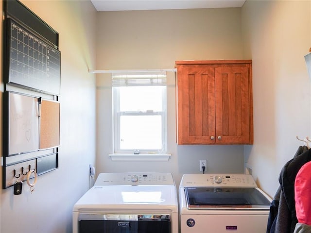laundry room featuring separate washer and dryer and cabinet space