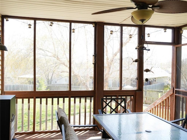 sunroom with ceiling fan, a healthy amount of sunlight, and outdoor dining space
