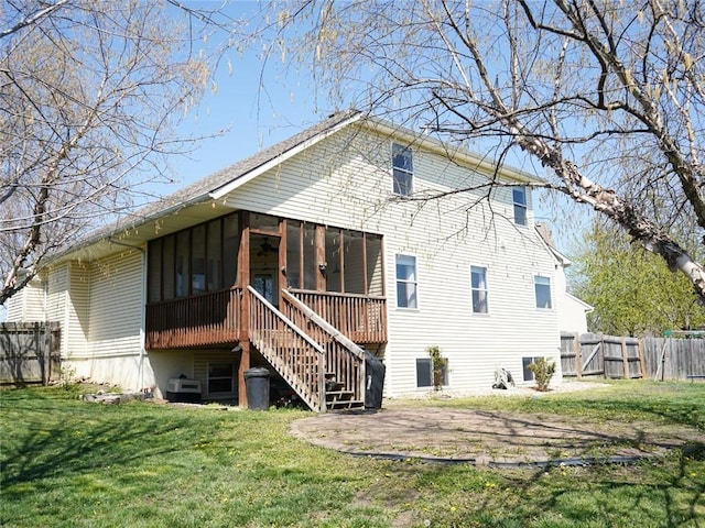 back of house with fence, a ceiling fan, a lawn, stairway, and a sunroom