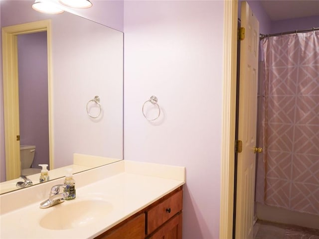 bathroom with vanity, curtained shower, and toilet