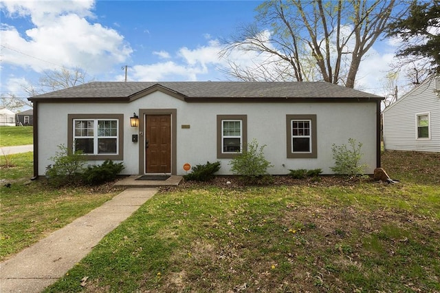 bungalow with stucco siding and a front lawn