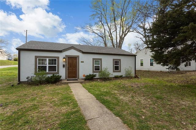 bungalow featuring stucco siding and a front lawn