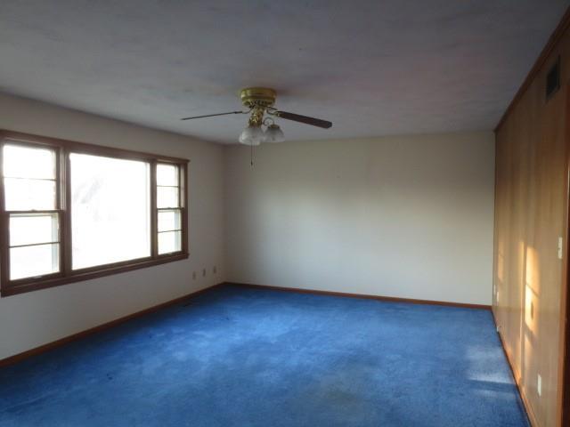 spare room with visible vents, ceiling fan, carpet flooring, and baseboards