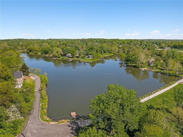 drone / aerial view of a heavily wooded area and a nearby body of water