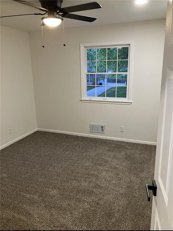 empty room featuring visible vents, a ceiling fan, baseboards, and carpet flooring