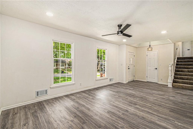 11715 E 60th St, Kansas City, MO 64133 - unfurnished living room with ceiling fan, visible vents, dark wood-style flooring, and stairway