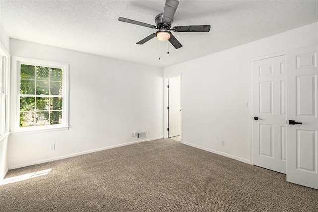 11715 E 60th St, Kansas City, MO 64133 - unfurnished bedroom featuring carpet floors, a textured ceiling, visible vents, baseboards, and ceiling fan