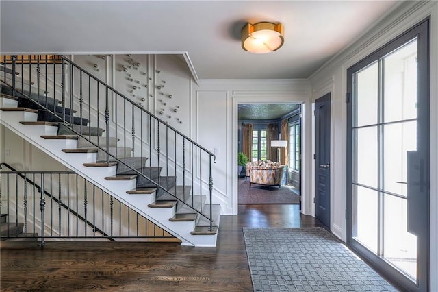 foyer featuring crown molding, stairs, and wood finished floors