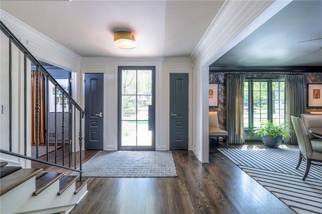 entryway with crown molding, stairs, and a wealth of natural light