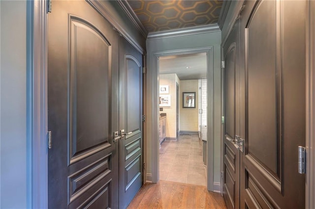 corridor featuring crown molding and light wood-style floors
