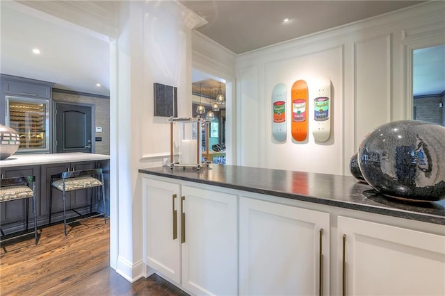 bar featuring dark wood-type flooring, recessed lighting, and crown molding