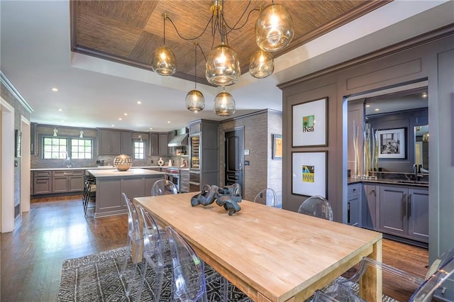 dining area featuring crown molding, recessed lighting, a raised ceiling, and dark wood-style floors