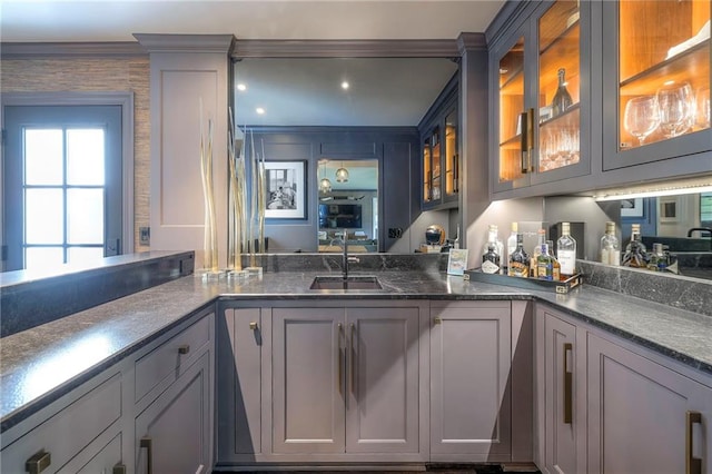 bar featuring a sink and crown molding