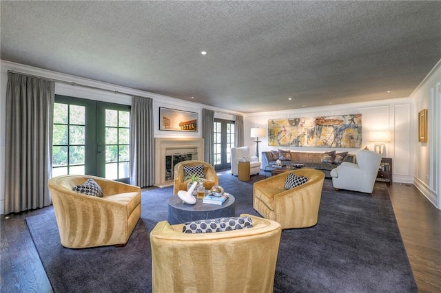 living area with crown molding, a textured ceiling, french doors, and wood finished floors