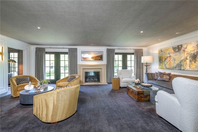 living room with plenty of natural light, french doors, a textured ceiling, a glass covered fireplace, and carpet