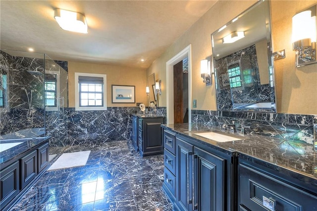 bathroom featuring a bath, a marble finish shower, a sink, and marble finish floor