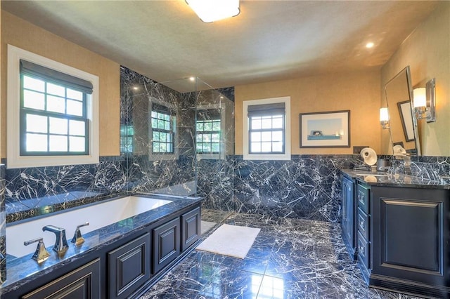 full bathroom with a walk in shower, vanity, marble finish floor, tile walls, and a bath