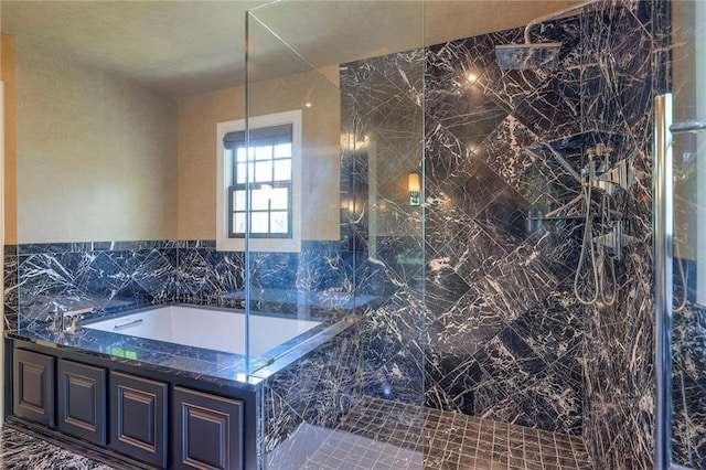 full bathroom featuring a marble finish shower and a bath