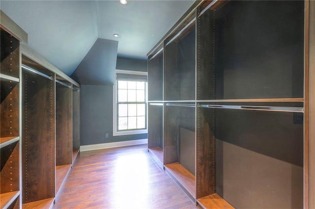 walk in closet with wood finished floors and lofted ceiling