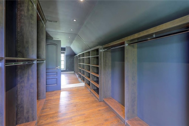 walk in closet with vaulted ceiling and wood finished floors