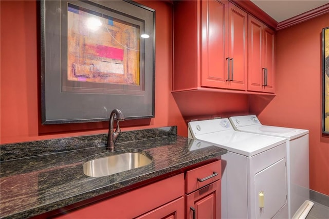 laundry area featuring ornamental molding, baseboards, separate washer and dryer, a sink, and cabinet space