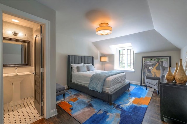 bedroom featuring baseboards, a sink, wood finished floors, and lofted ceiling