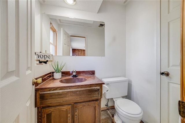 half bath with vanity, visible vents, and toilet