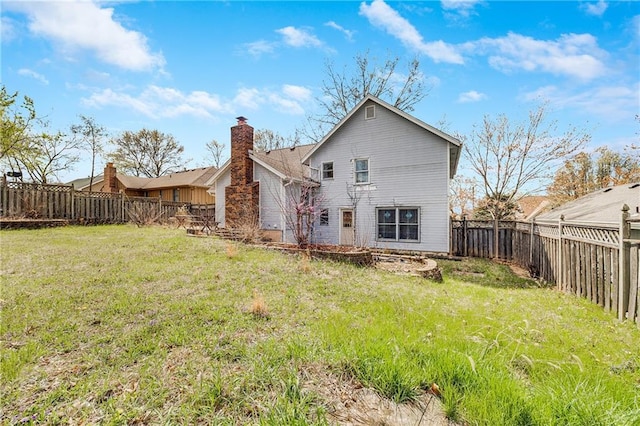 back of house featuring a fenced backyard and a lawn