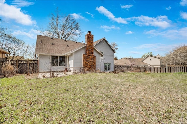 back of house with a chimney, a fenced backyard, and a lawn
