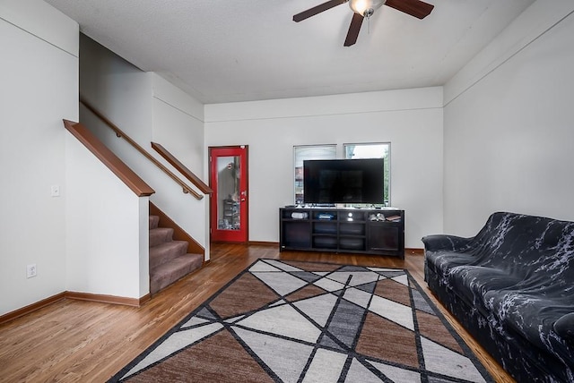 1210 Barnett Ave, Kansas City, KS 66102 - living area featuring wood finished floors, a ceiling fan, stairs, and baseboards