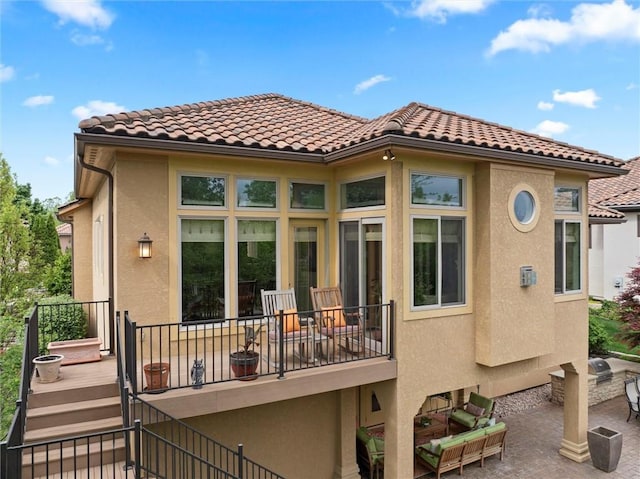 back of property with stairway, a patio, a tiled roof, and stucco siding