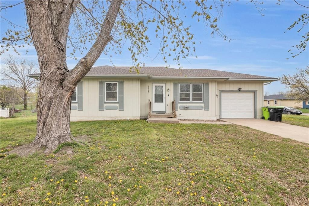 single story home featuring driveway, an attached garage, and a front lawn