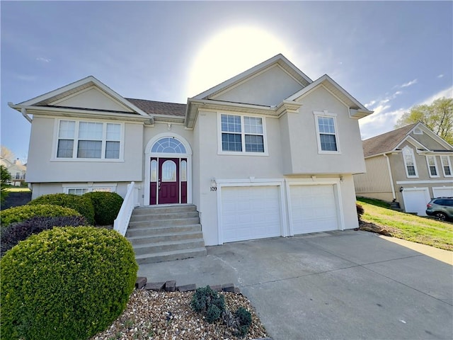 109 Deerfield Dr, Warrensburg, MO 64093 - bi-level home featuring concrete driveway, an attached garage, and stucco siding