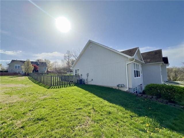 109 Deerfield Dr, Warrensburg, MO 64093 - view of side of home featuring central AC unit, fence, and a lawn