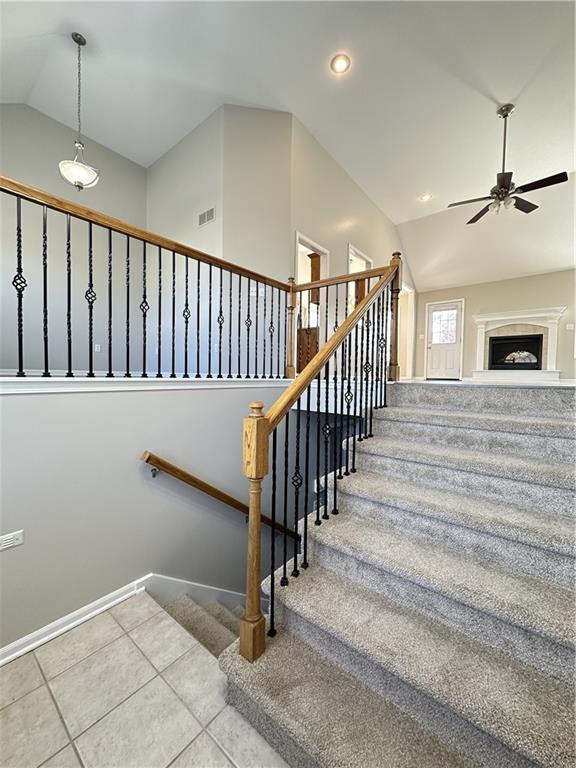 109 Deerfield Dr, Warrensburg, MO 64093 - stairway with vaulted ceiling, recessed lighting, tile patterned floors, visible vents, and ceiling fan