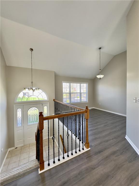 109 Deerfield Dr, Warrensburg, MO 64093 - entrance foyer with wood finished floors, an inviting chandelier, baseboards, and lofted ceiling