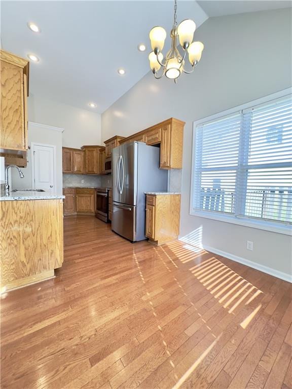 109 Deerfield Dr, Warrensburg, MO 64093 - kitchen featuring hanging light fixtures, a notable chandelier, a sink, stainless steel appliances, and light wood-style flooring